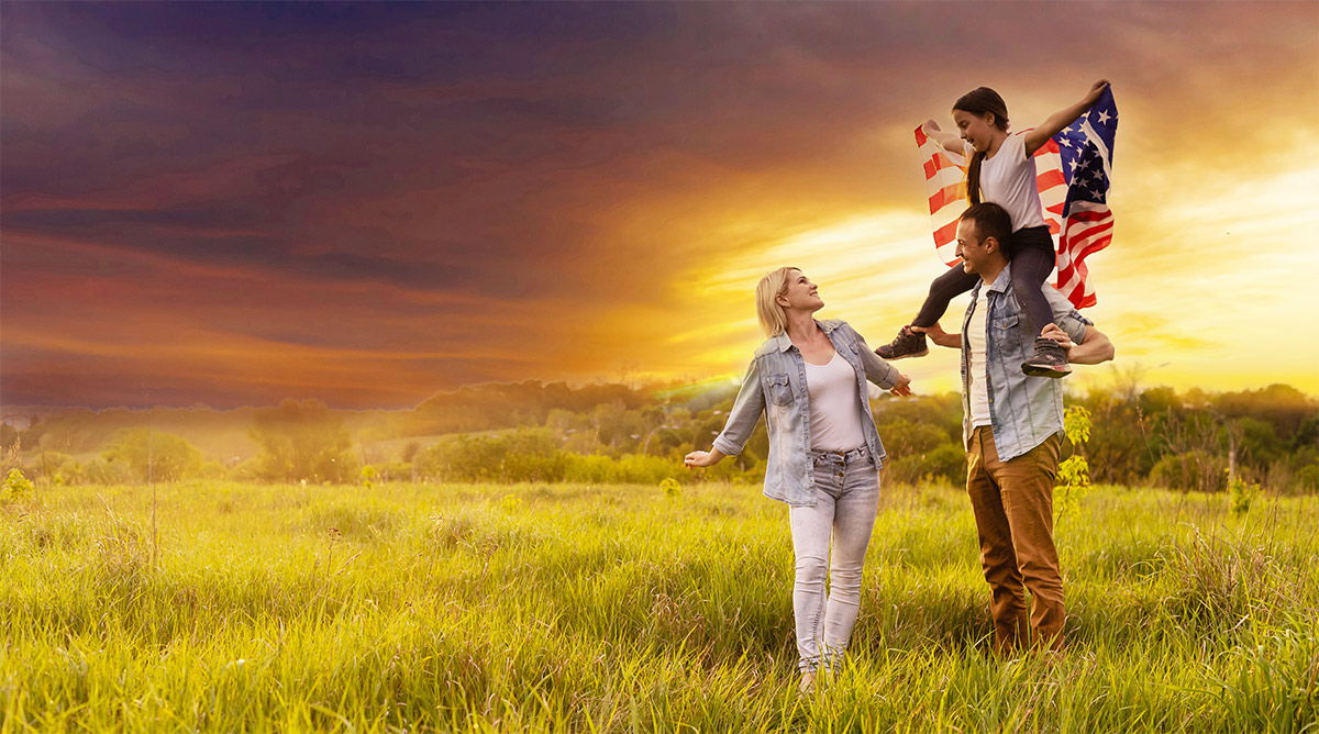 Couple in a field with a child holding a flag