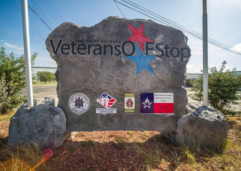 A large stone with "The Heart of Texas Veterans One Stop" logo; one red star, on blue star. Additional logos: "Heart of Texas MHMR Center", "Texas Veterans Commission", "Military Veteran Peer Network", and "McLennan County Veterans Service Office 1850".