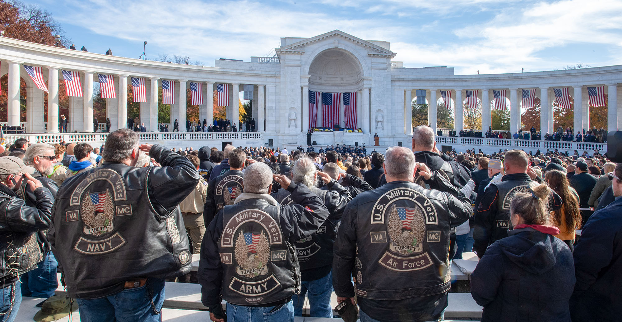 A diverse group of Veterans rendering a salute at the World War II memorial.